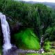 pexels-photo-414061-414061 A breathtaking waterfall cascading into lush greenery in a serene forest setting.